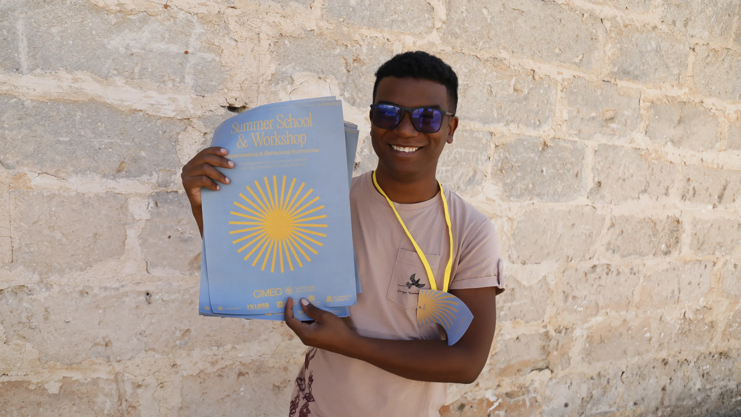 Participante con un montón de carteles de la escuela de verano con el sol amarillo